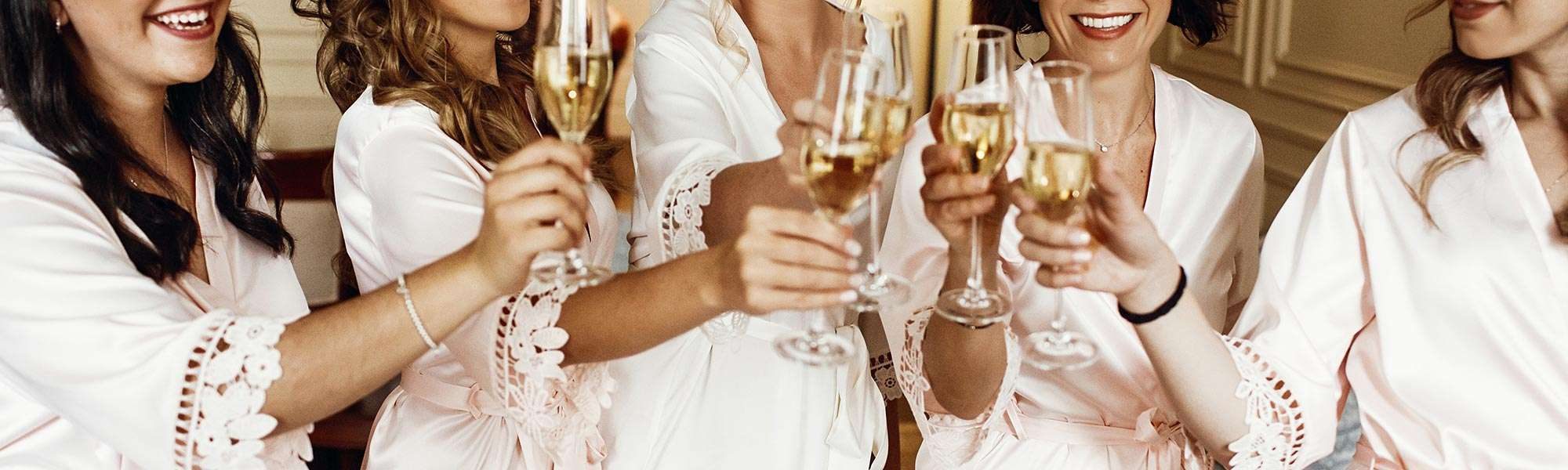 Bridesmaids in robes toasting champagne