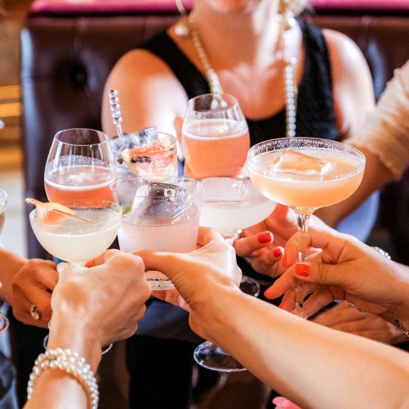 women hold cocktails toast