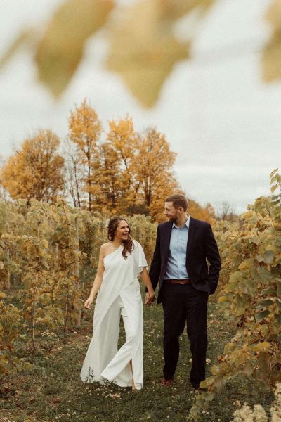 couple walks through strigo vineyards in the fall